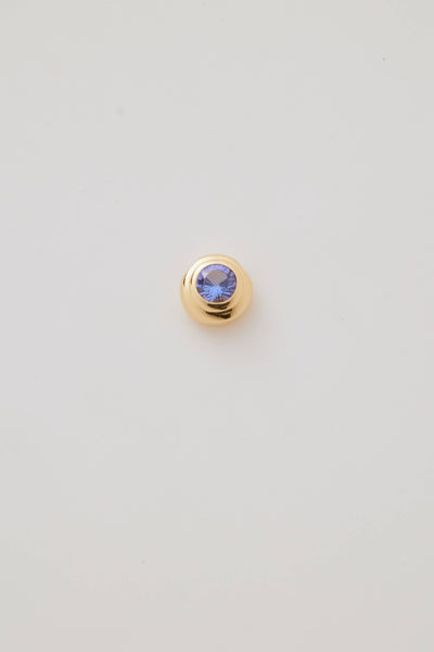 Close-up image of the December Birthstone Charm featuring a stunning tanzanite gemstone with deep blue and violet hues in a polished gold setting.