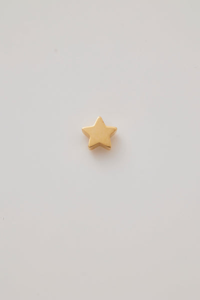 A solid gold star pendant with a smooth, polished surface, showcasing its clean lines and symmetrical five-pointed design. The pendant has a small hole at the top for attaching to thread a chain, through blending seamlessly with the star's sleek, shiny finish.