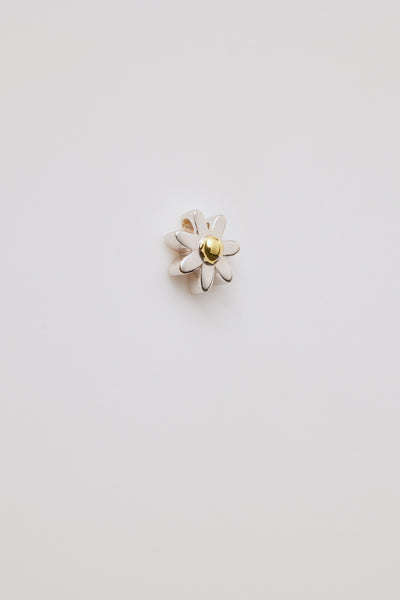 A gold three-dimensional daisy charm with detailed petals and a centre hole for threading a chain. Elegant and versatile.