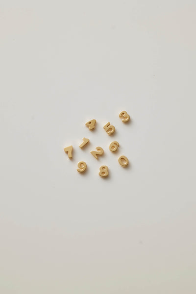 A collection of gold numbers from 0-9 symbolizes luck and individuality, offering a timeless and elegant way to celebrate a milestone or important date.