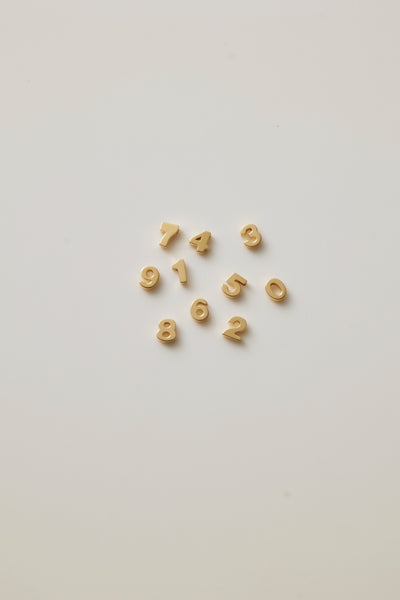 A photo showing gold numbers from 0-9 which symbolises luck and individuality, offering a timeless and elegant way to celebrate a milestone or important date.