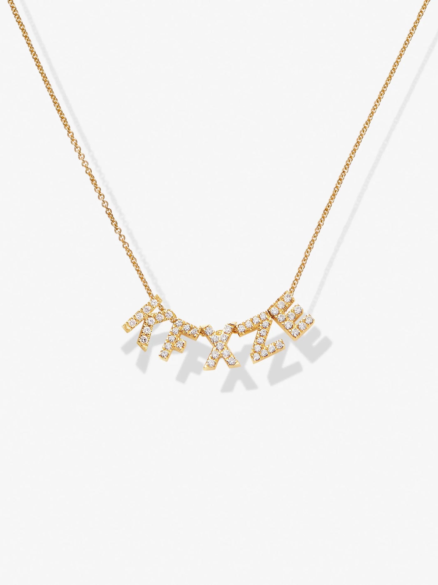 The Five Letters Necklace in Diamonds and 18k Gold features a delicate chain with hanging letters adorned with small round brilliant  diamonds, "KFXZE." Crafted from 18k solid gold, the letters dangle slightly, creating a shimmering effect against a plain white background.