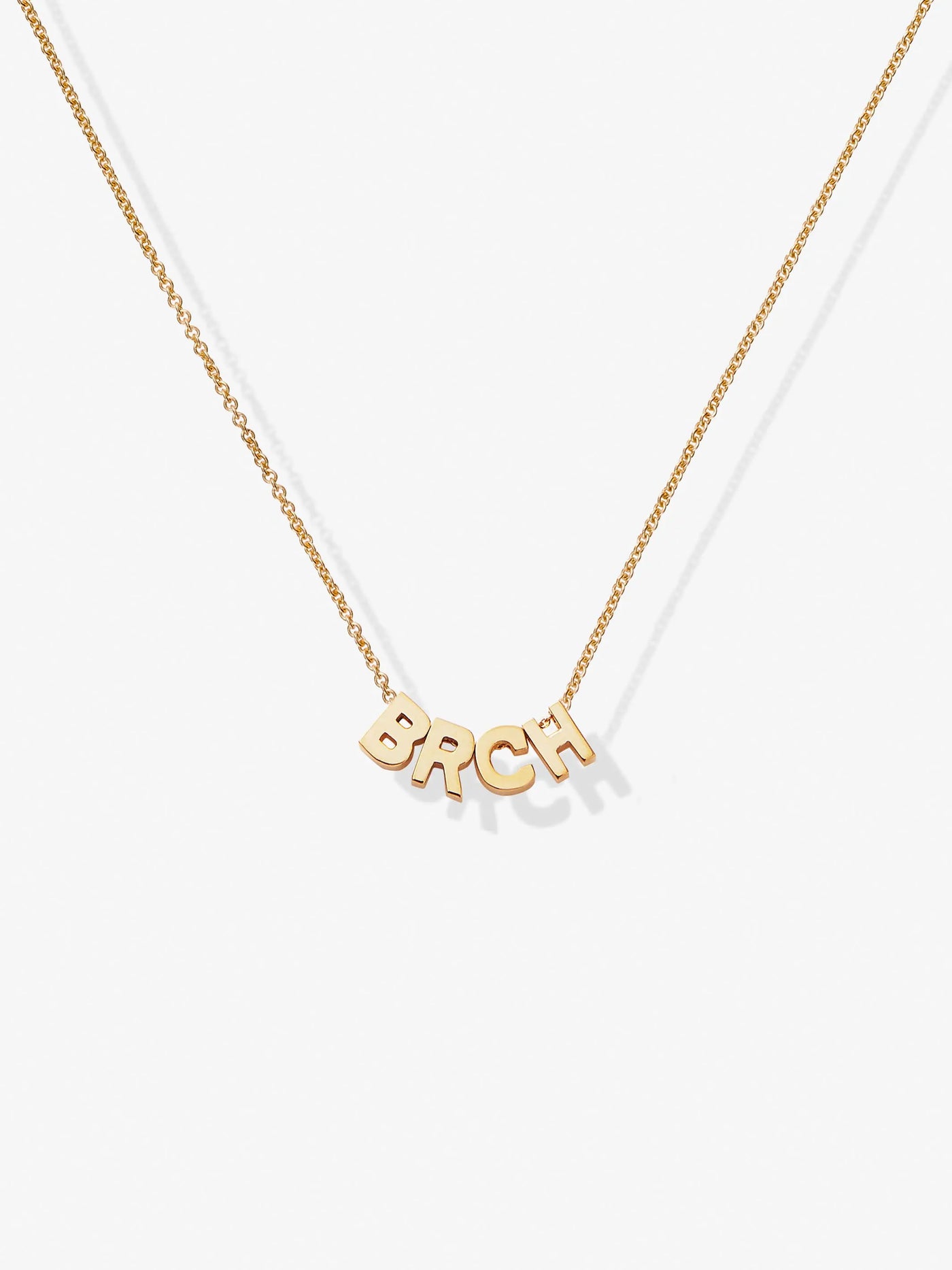 A delicate 18k solid gold necklace named the Four Letters Necklace in 18k Gold, showcases a fine chain with letters BRCH letter charm pendants, elegantly displayed against a plain white background.