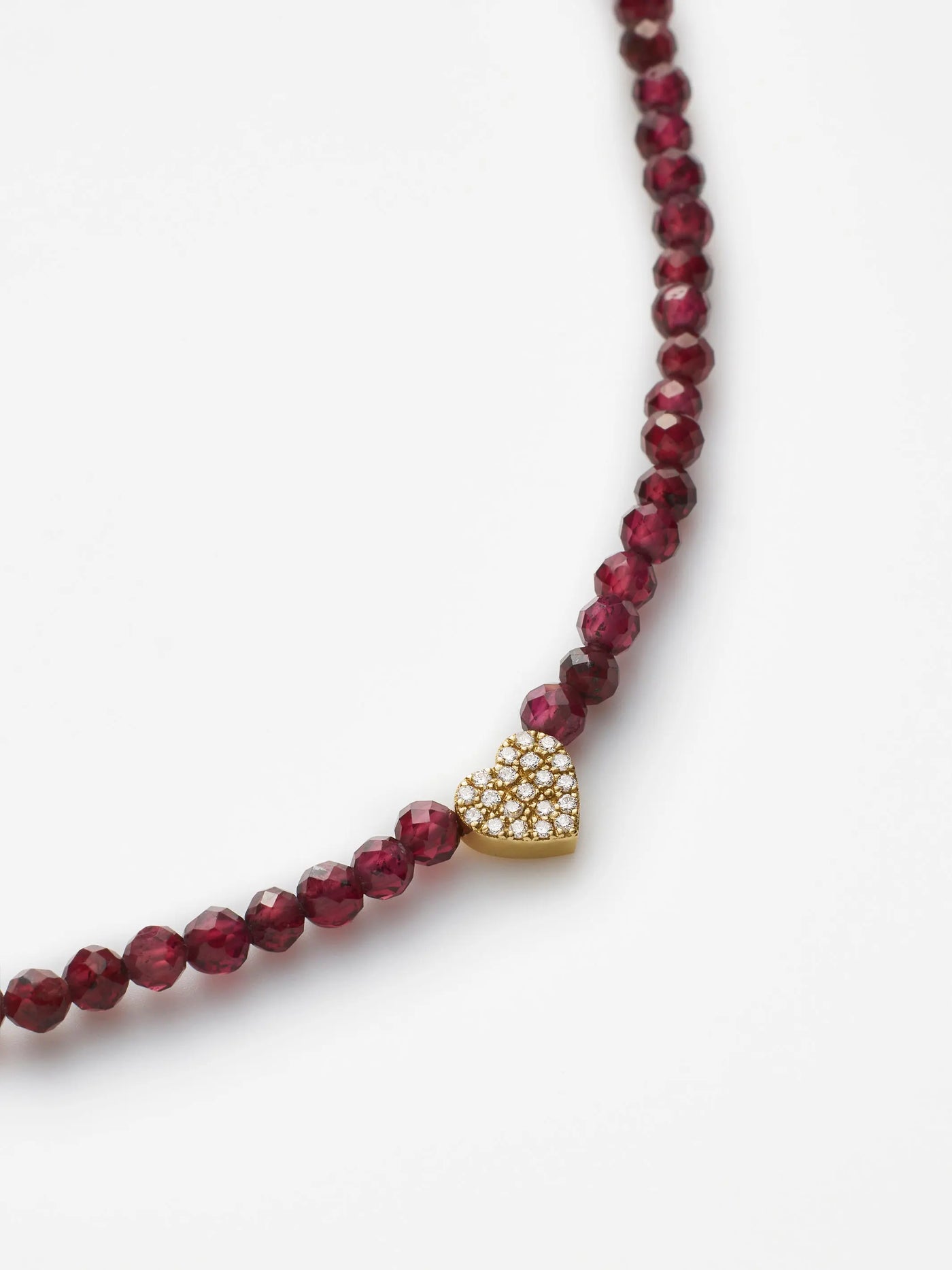 Hand-strung bracelet with garnets and miniature three-dimensional diamond heart in 18k solid gold