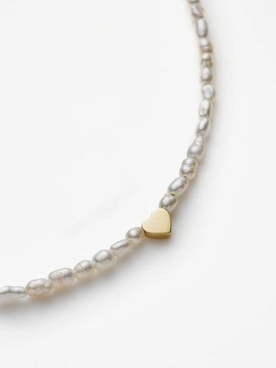 Hand-strung bracelet with natural freshwater pearls and miniature three-dimensional heart in 18k solid gold