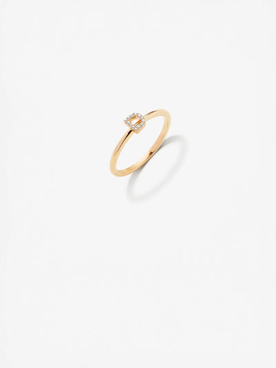 Presenting the exquisite Letter D Ring, crafted in 18k gold with a minimalist band design. This elegant piece showcases a small, square-shaped cluster of radiant diamonds at its center. The ring is displayed on a plain white background to highlight its sophisticated beauty.