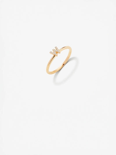 The Letter W Ring in Diamonds and 18k Gold showcases a custom-made design with a delicate 18k gold band. The central "W" shape is adorned with small, sparkling diamonds, all presented against a plain white background that casts a subtle shadow.