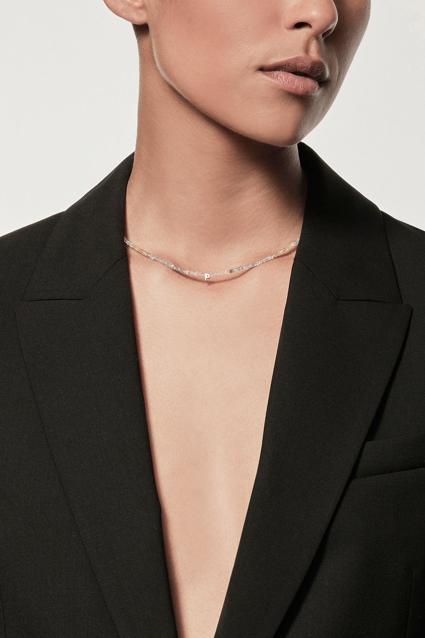 Women wearing a black blazer and Faceted aquamarine beaded collier necklace with gold accents on silk thread