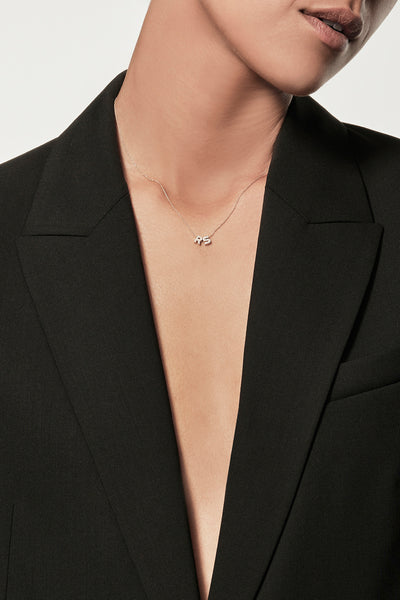 A delicate 18k solid gold necklace featuring two small, capital letter charms encrusted with diamonds. This stunning Two Letters Necklace in Diamonds and 18k Gold is displayed against a plain white background.