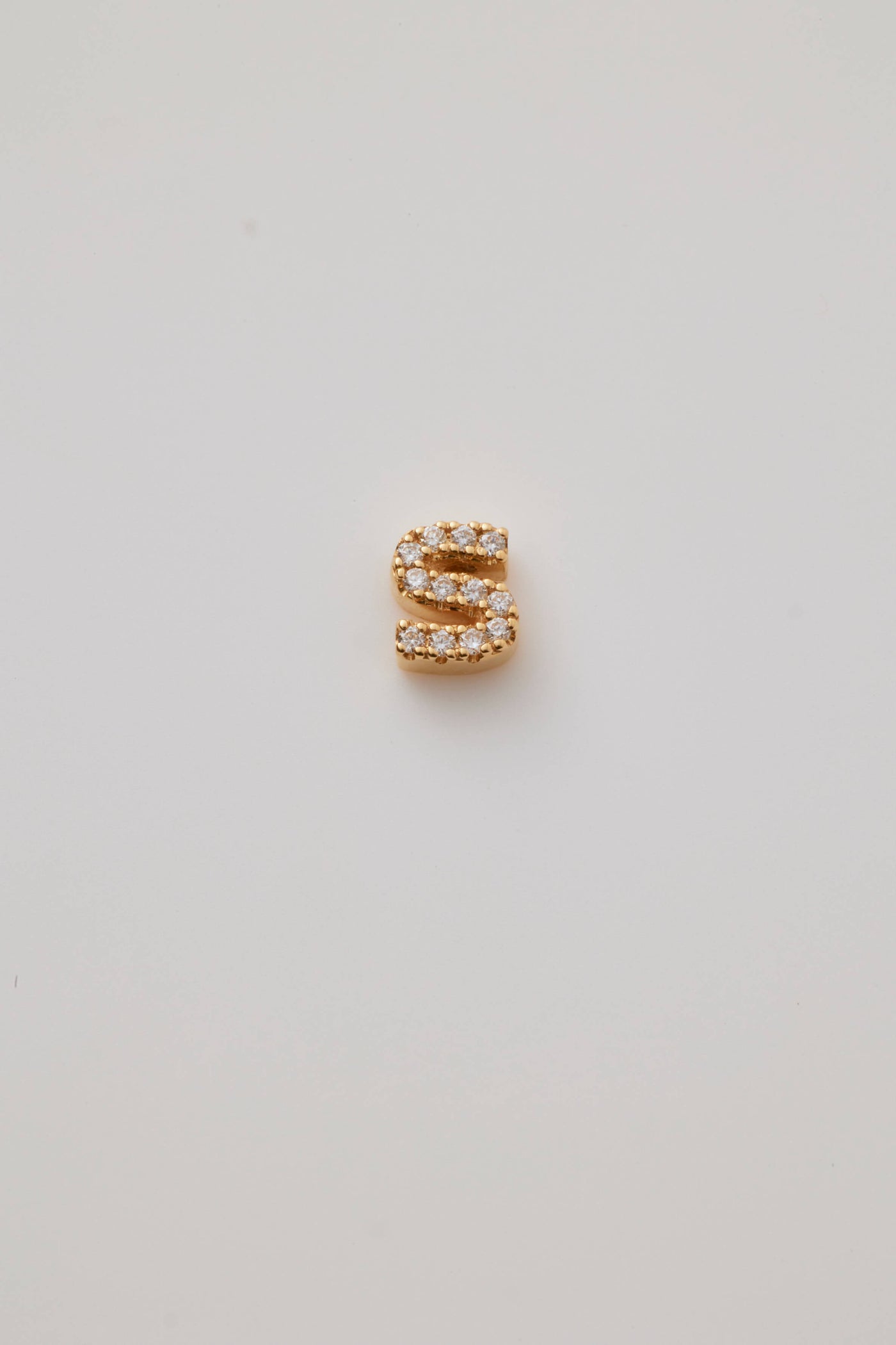 Small solid gold three-dimensional letter 'S' charm with pavé set diamonds, designed to thread onto a necklace chain.