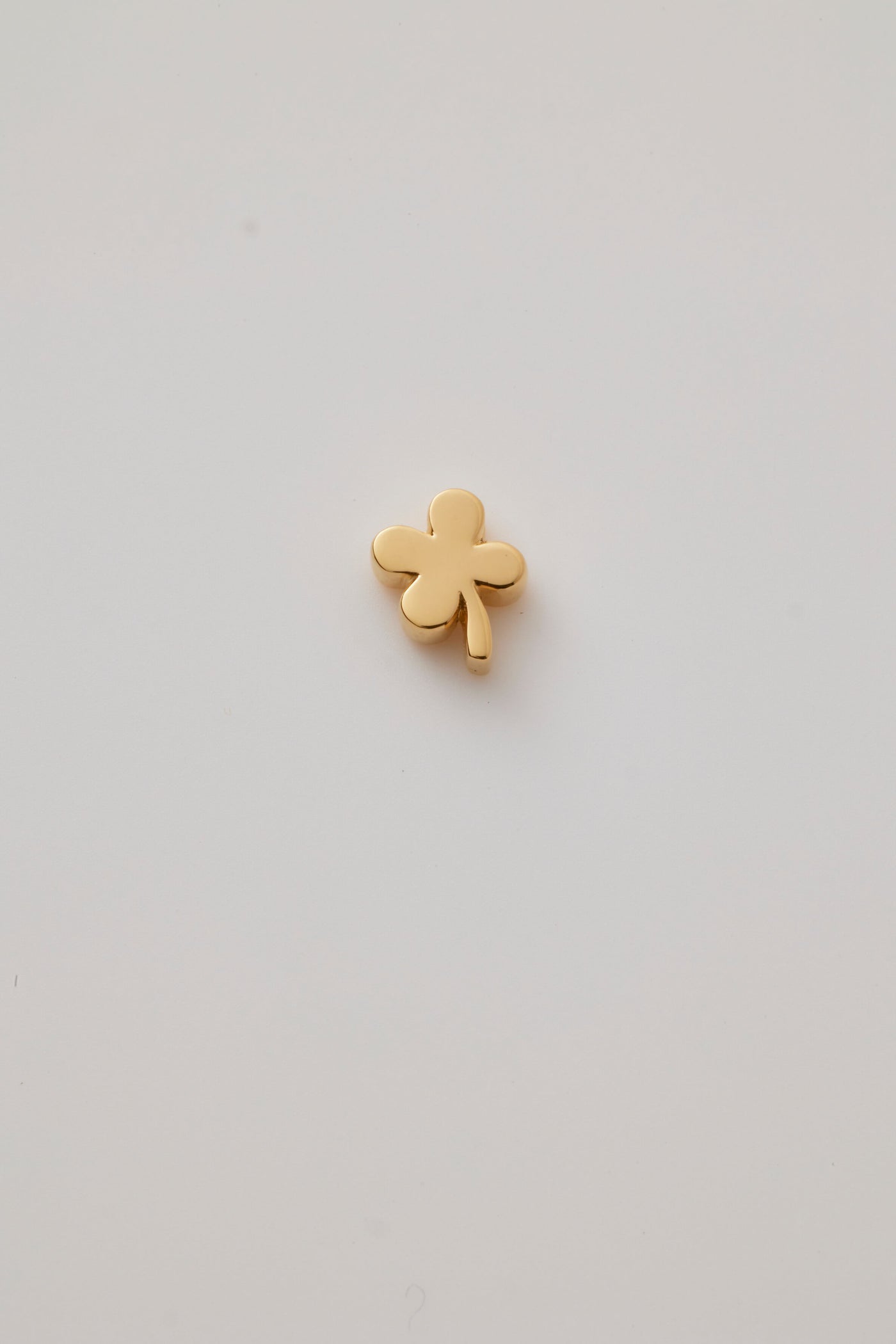 Solid gold four-leaf clover charm representing luck, hope, faith, and love, designed to slide onto a necklace chain for a timeless keepsake