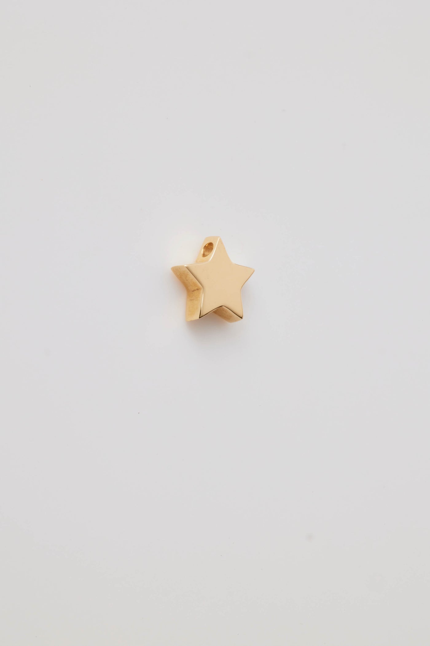 Polished solid gold star charm, a symbol of remembrance and love.