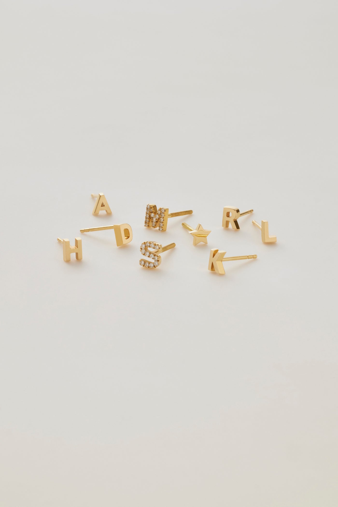 Single 18k gold letter stud earring pavé set with Round Brilliant-cut diamonds, shown as a personalised initial design.